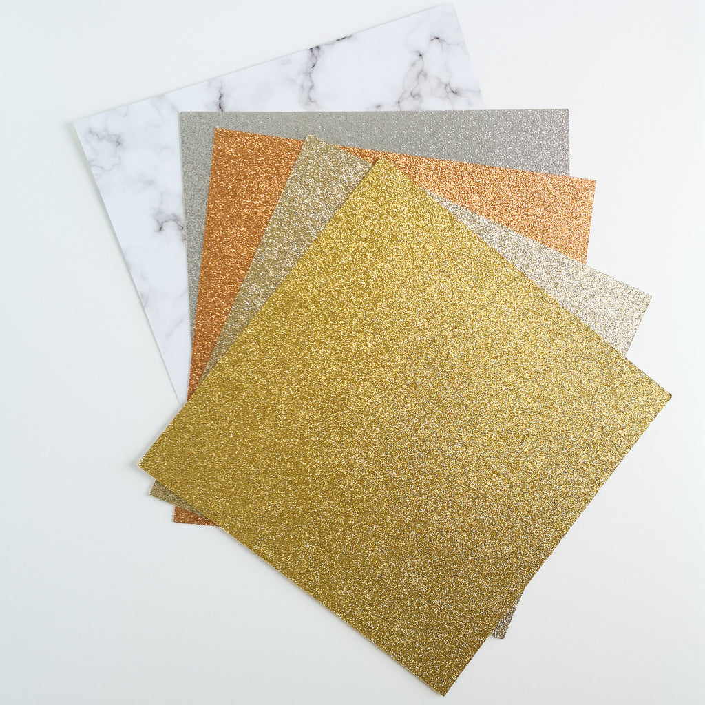 Stack of 12 x 12 glitter cardstock made from recycled materials in gold, champagne gold, rose gold or copper, & silver